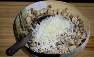 Add the rest of the grated cheese to the chicken and mushrooms.