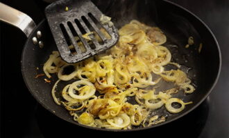 Remove the meat from the pan, and instead add the onion cut into strips and sauté for several minutes.