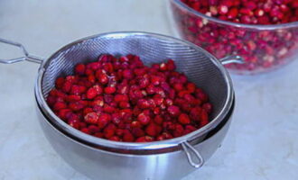 Susun strawberi, basuh dan letakkan dalam colander untuk longkang.