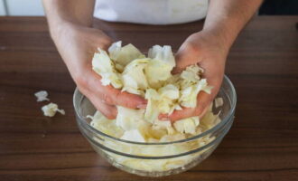 Place the cabbage in a bowl, sprinkle it with sugar and mix with your hands.