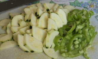 Remove the peel and seeds from the zucchini and cut into half circles. Cut the peeled sweet pepper into strips.