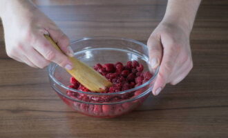 Vierte las frambuesas en un bol de tamaño adecuado y tritúralas ligeramente para que las bayas suelten su jugo, pero no las hagas puré. 