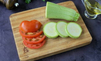 Corte a abobrinha em rodelas, corte os tomates em rodelas finas.