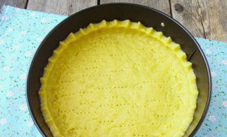 Quindi stendere l'impasto. Ungete lo stampo con olio vegetale, metteteci dentro l'impasto e fate degli stivaletti. Bucherellare l'impasto con una forchetta. Mettete la teglia con la torta nel forno, preriscaldato a 200 gradi per 18 minuti.