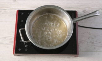 Giet suiker in een pan en vul met water. Zet de pan op het vuur en breng de inhoud aan de kook, kook de siroop gedurende 2 minuten.