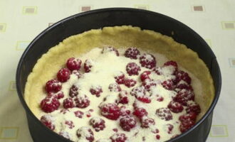 Place raspberries on the dough, cover them with sugar and semolina.