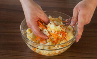 Add vinegar and carrots with spices to the cabbage, add salt and mix well.