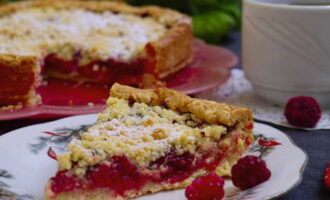 Saupoudrer la tarte aux framboises finie de sucre en poudre, laisser refroidir légèrement et servir avec du thé.