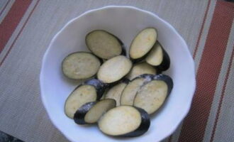 How to cook delicious eggplants in Georgian style? We wash the vegetables and cut them into slices of equal thickness. Sprinkle them with salt, stir and leave for 15 minutes.