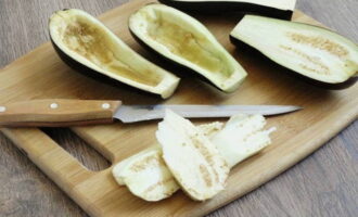 How to cook stuffed eggplants in the oven? We wash the vegetables with running water. When the moisture dries, cut the eggplants into two halves along the fruit. Using a small spoon, remove the pulp. Grind a small amount of salt in boats. Cut the eggplant pulp into small pieces.