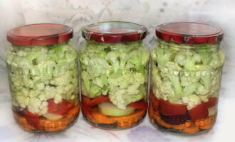 Place the cabbage in the prepared container, sprinkle it with pieces of pepper, garlic and carrots, and then pour in the prepared marinade. Allow the jars to cool and then place in a cool place. The cabbage will be ready in about a day. Bon appetit! 