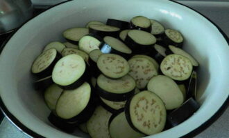 How to prepare delicious spicy eggplants for the winter? We divide the washed eggplants into circles of equal thickness. Add salt to them, stir and leave for 1 hour.