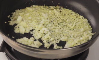 We try to chop the peeled onion as finely as possible. Pour it into a preheated frying pan with oil and fry until the onion becomes softer.