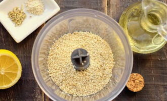 Let's get started with sesame seeds. Pour it into the blender bowl. Add one tablespoon of olive oil here.