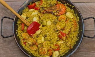 Place rice and grated tomatoes into the pan. Fill the contents with saffron and water, as well as the broth left over from the shrimp. Add salt and spices. Cook for 15 minutes on low heat.