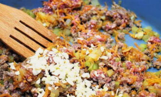 Simmer the contents until the ground beef is ready and supplement it with chopped garlic cloves.