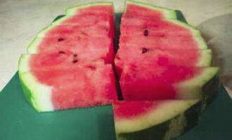 Schneiden Sie die Wassermelone zusammen mit der Schale in rechteckige Scheiben.