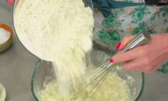 After this, add the sifted flour in parts.Start mixing the ingredients with a whisk.