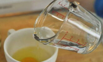 Pour water into a mug with an egg and add vinegar.