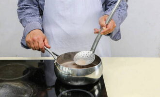 Durante o cozimento, retire a espuma com uma escumadeira. Quando a água ferver, acrescente óleo vegetal, reduza o fogo e cozinhe o mingau por 6 a 8 minutos.