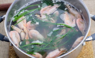 As soon as the first bubbles begin to appear in the broth, lower the unpeeled shellfish, bring to a boil again and turn off. Then cover with a lid and after two minutes remove the shrimp using a slotted spoon.