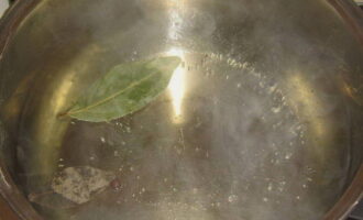 How to cook delicious cabbage soup from nettles? Pour the required amount of water into the pan. Bring the water to a boil and add salt and bay leaf to it. 