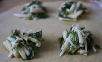 Take the ravioli dough out of the refrigerator and divide it into two parts. Spread the filling onto one part using a teaspoon. Maintain a distance of 2-2.5 cm.