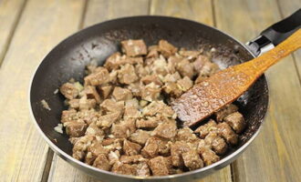 Fry the meat, stirring occasionally, until golden brown, then add chopped onion to the pan.