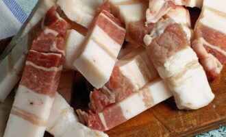 Dopo 8 ore tagliare il lardo a fettine. Ora potete iniziare a formare gli spiedini. Disporre gli ingredienti sugli spiedini nel seguente ordine: anello di cipolla, pezzo di carne, fetta di lardo.