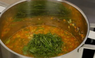 As soon as the liquid boils, add bean pods to the pan and cook for another 10 minutes until the potatoes are fully cooked. 7 minutes before turning off the soup, add garlic with chopped basil and, if necessary, add salt and ground pepper. Mix all the ingredients well and continue to cook the soup over low heat until fully cooked.