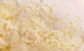 Cut the onion into thin half rings and place in a frying pan, fry in vegetable oil for about 3-5 minutes, stirring occasionally.