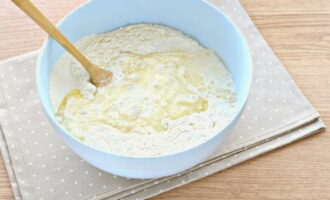 Then pour the milk-yeast mixture into this cavity and gradually knead the dough.