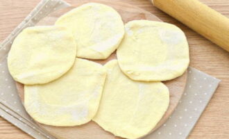 Then each ball must be flattened and rolled out with a rolling pin on a surface sprinkled with flour.Since the flatbreads are wide, the pies will turn out quite large.