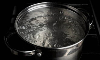 Gießen Sie 3 Tassen kochendes Wasser in einen Topf mit geeignetem Volumen, fügen Sie Graupen hinzu, kochen Sie es 5 Minuten lang bei starker Hitze und lassen Sie das Wasser dann abtropfen.