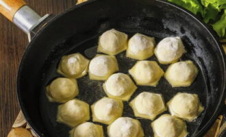 Put it on the fire quickly, pour in the vegetable oil and heat it thoroughly, then reduce the heat to low and add the dumplings. Fry them covered for about 4-5 minutes.