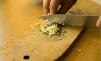 Chop the garlic and add it to the chicken along with salt and spices. Mix everything thoroughly.