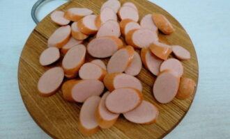 The sausages are cut into slices and lightly fried, then you need to put them in another bowl. 