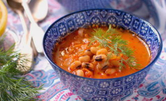 Tomato frying is mixed with sausages and added to the soup. Canned beans are also added there. Season the dish with more salt and pepper if needed, then cook for about 7 minutes. The soup should be served with sour cream and herbs. 