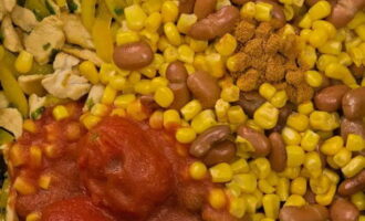 Next, add canned beans, corn, cumin, chili peppers and tomatoes. Mix the ingredients well and fry for 3 minutes.