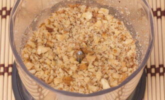 Walnuts are chopped into crumbs with a knife or ground in a blender. Prunes and nuts are placed on a layer of meat. Coat with mayonnaise or sour cream. 