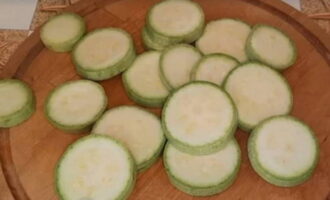 Bagaimana untuk memasak zucchini jeruk segera? Basuh sayuran dengan teliti, keringkan dengan tuala kertas dan potong cincin nipis.