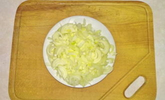 Now let's prepare the frying. Wash and peel the onions and carrots. Cut the onion into half rings. Heat a couple of tablespoons of vegetable oil in a frying pan and fry the onion in it until golden brown.