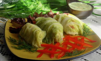 Remove the finished cabbage rolls from the water and transfer them to a plate. Serve with any additions to your taste.