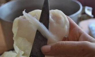 Let's return to boiled cabbage leaves. For each sheet, you need to cut off the outer protruding part (as in the photo) and tear each one into two equal parts. We place all the waste and torn leaves on the bottom of the pan in which the cabbage rolls will be cooked. 