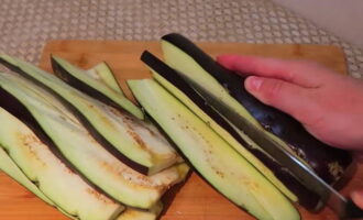 Hoe maak je gevulde auberginebroodjes met kaas en knoflook? De aubergines worden gewassen, de uiteinden worden afgesneden en het grootste deel wordt verdeeld in plakjes van niet meer dan 5 mm dik. 