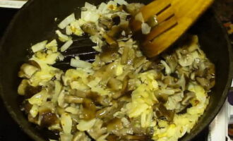 Transfer the prepared honey mushrooms to the fried onions, stir with a spatula and fry for another 3 minutes.