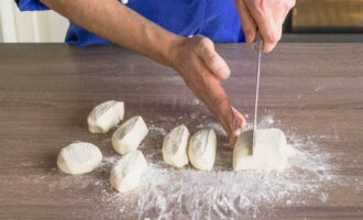 Abra a massa resultante até formar uma salsicha, divida em porções e forme cheesecakes, polvilhando levemente com farinha para que não grudem nas mãos. 