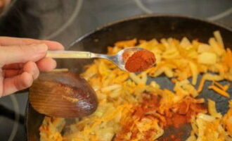 In a separate pan, fry the onions and carrots, add paprika to the vegetables. 