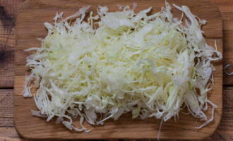 How to prepare a salad of cabbage, peppers and carrots for the winter? Let's start with cabbage. Remove the top leaves and rinse thoroughly under running water. Next, dry it with a paper or cotton towel. Now finely chop it with a knife or use a food processor. Don't forget to cut out the stalk. Transfer the chopped cabbage to a deep bowl.