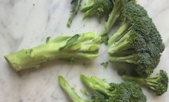 Hvordan laver man hurtigt og velsmagende frisk broccoli i en stegepande? Skær broccolien i små buketter med en kniv, og fjern de tykke stilkebunde. Fyld derefter blomsterstandene med koldt vand i 10 minutter.